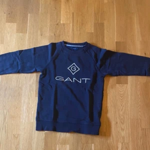 Mörkblå sweatshirt från GANT - Säljer en snygg mörkblå sweatshirt från Gant som är använd endast 2 gånger. Skick 9.9/10 och såklart inga defekter. Priset går att diskutera vid snabb affär och skicka ett meddelande vid minsta fundering eller fråga.