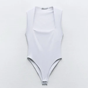 Vit ärmlös bodysuit från Zara - Snygg och stilren vit bodysuit från Zara med fyrkantig urringning. Den är ärmlös och har en tight passform som framhäver figuren. Perfekt att matcha med jeans eller kjol för en chic look. 💓💓