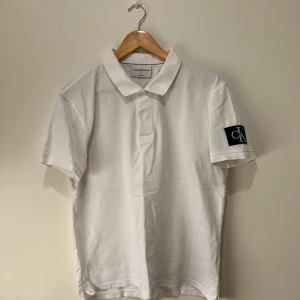 Vit pikétröja från Calvin Klein - Säljer en  vit pikétröja från Calvin Klein. Den har använts ett par gånger men är i bra skick lite missfärgning under armarna men inget fel annars och loggan på vänster arm är helt perfekt! Köptes för 950kr och säljer den för mindre än 50% av priset! 
