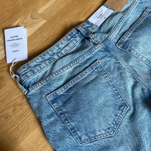 Säljer ett par blå jeans i klassisk rak passform. Perfekta för både vardag och fest, med fem fickor och knappgylf. I nyskick och helt oanvända. Perfekta för den som älskar stiliga och funktionella plagg!