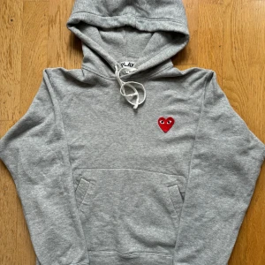 Cdg hoodie - Grå Cdg hoodie i storlek L. Är använd några gånger men fortfarande i bra skick (8/10). Är köpt second hand så har inget kvitto. Pris kan diskuteras vid snabb affär OBS! Är liten i storleken 