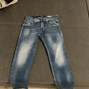Blå jeans från Replay - Säljer ett par snygga blå jeans från Replay i modellen Anbass. Jeansen är helt felfria och helt nya! Använt endast 1 gång innan. Skriv till mig om ni har några frågor eller om ni vill ha fler bilder! Storlek 28x30