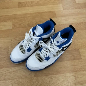 Air Jordan 4 retro ”Motorsports” - Som nya! Använda 1 gång.  Väldigt fin skick på skorna och svåra att få tag på. Dem flesta säljer dem överpris.   Färg: Vit,Blå,Svart Storlek: US-10.5/EU-44.5 Skick: 9.9/10
