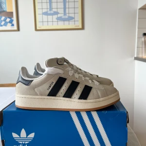 Adidas Campus 00s - Säljer mina Adidas Campus 00s i färgen Crystal White då de är lite för små för mig. Storlek 40 2/3 men sitter som en 40. Endast använda ett fåtal gånger, inga defekter och i väldigt fint skick! Köpta för 1349kr från Nelly.com 🌸🫶🏼🫶🏼