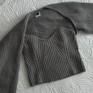Grå stickat set  - Jag säljer detta sköna settet!🤍Det är en stickad bandeau top som kommer med matchande kofta. Använt den max två gånger. Skriv om ni har några funderingar!💕