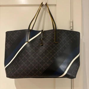 By Malene Birger Grineeh  handväska och plånbok - By Malene Birger Grineeh  handväska och plånbok  Mycket vacker väska från By Malene Birger i svart och brunt. I perfekt skick.                                                                  Article number  Q62344043/GRINEEH  Väskan 27,5x41 cm. Plånboken 15,5x21 cm