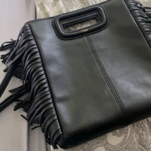 Maje väska - Intressekoll!! Säljer min fina maje väska som tyvärr inte kommer tills användning längre. Den är köpt på plick men i väldigt bra skick . Den är svart i läder och i mellan storleken! Om fler bilder önskas är det bara att skriva💕💕 kan sälja för ett bra pris, många intresserade så skriv hur mycket ni är villiga att lägga!