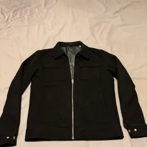 Svart jacka från Jack & Jones - Snygg svart jacka från Jack & Jones med dragkedja framtill och två bröstfickor . Skick 9/10. 