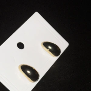 Guld örhängen - Eleganta örhängen i guld med en droppformad design. Perfekta för att ge en stilren touch till din outfit. 