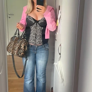 Leopardmönstrad korsett - Snygg leopardmönstrad korsett med svarta detaljer. Den är kanappt andvänd och i väldigt bra skick det är ganska mycket push up i själva bh delen.kommer inte till andvändning där av tänker jag sälja den 