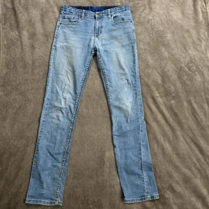 Ljusblå jeans från Levi's - Snygga ljusblå jeans från Levi's med klassisk femficksdesign och knappgylf. De har en straight passform och är perfekta för en avslappnad stil. Levi's-loggan syns tydligt på baksidan.