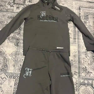 Grå eternal hoodrich tracksuit  - Säljer en stilren grå hoodie från Hoodrich med tryck på bröstet och ryggen. Hoodien har en klassisk passform med långa ärmar och en bekväm huva. Aldrig använd.