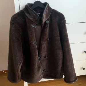Brun fuskpäls - Jacka från H&M Divided i storlek S. Använd vid ett tillfälle så i nyskick. Ofodrad. 