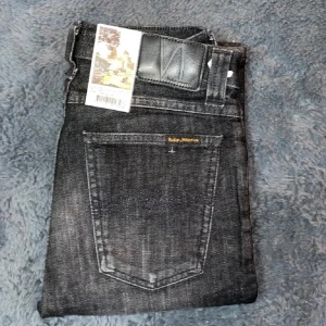 Svarta jeans från Nudie Jeans - Snygga svarta jeans från Nudie Jeans med en klassisk femficksdesign. De har en slim passform och är tillverkade i högkvalitativt denim. Perfekta för en stilren look. Helt nya! (Bilderna är från mella shop)