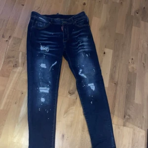 Blå jeans från Dsquared2 - Snygga blå jeans från Dsquared2 med slitna detaljer och en cool, distressed look. De har en klassisk femficksdesign och en bekväm passform. Perfekta för en trendig och avslappnad stil.