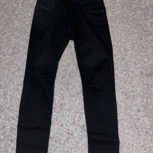 Svarta jeans från Levi's Premium - Snygga svarta jeans från Levi's Premium. De har en klassisk design med fem fickor och en knappgylf. Perfekta för en stilren look.