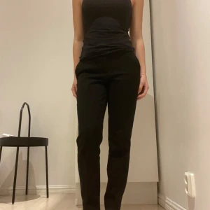 Svarta kostymbyxor från H&M - Snygga svarta kostymbyxor i straight modell från H&M i storlek 34. Byxorna har en klassisk design med dragkedja och knapp framtill. Innerbenslängd 69cm . Knappt använda därav priset. 💕