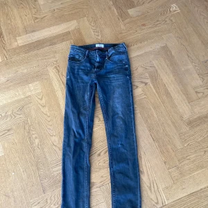 Blå jeans från Vingino - Snygga blå jeans från Vingino med en klassisk femficksdesign. De har en knapp och dragkedja framtill samt en liten italiensk flagga som detalj vid fickan. Perfekta för en avslappnad stil. Skinny fit