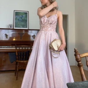 Jättefin balklänning - Elegant ljusrosa balklänning med glittrande detaljer och spets. Klänningen har en vacker v-ringad design och smala axelband. Bara använd en gång till 9ans avslutnings bal, därav en perfekt klänning för en bal eller festlig tillställning. Jag är 162cm och klänningen gick ner hela vägen till mina tår. 💓💓nypris 2000kr. Kan kanske gå ner i pris. Storlek 34/36