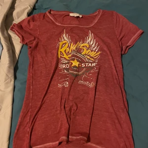 Röd t-shirt från Cream med tryck - Säljer en röd t-shirt från Cream med ett coolt tryck i gult och vitt. T-shirten har korta ärmar och en rund halsringning. Super skönt material!! Storlek xs😊😊