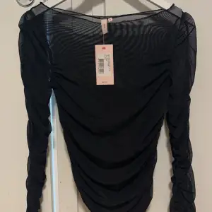 Säljer en snygg svart mesh topp från Nelly med långa ärmar och rynkade detaljer. Perfekt för en stilren look. Toppen är i ett transparent material som ger en trendig touch. Aldrig använd tyvärr. Pris går att diskutera💕💕