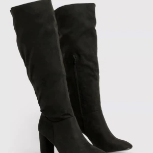 Svarta mocka stövlar med klack - Snygga svarta stövlar i mocka med hög klack och dragkedja på sidan. Perfekta för en stilren look.