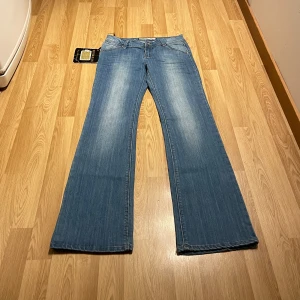 Lågmidjade bootcut jeans  - (11) Ljusblåa lågmidjade bootcut jeans i stretchiga material, helt ny med lappar kvar. Midjemått rakt över 35cm, innerbenslängd: 82 cm 💕