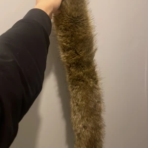 Brun pälsliknande halsduk - En moncler Päls till jackan. Kan användas till andra jackor såklart. Mycket fin päls förekommer även kvitto.  PRIS KAN DISKUTERAS 
