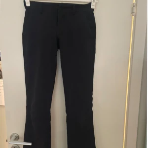 Low waist bootcut kostymbyxor - Snygga svarta kostymbyxor från BikBok i storlek 34. Mycket låg midja och och utsvängda. Har slits. Nypris: 499kr 