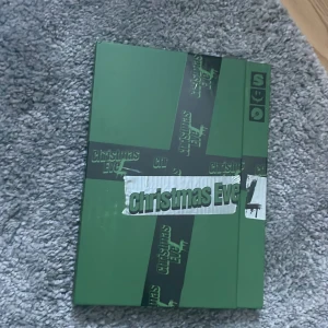 Christmas EveL album - Säljer ett album med titeln 'Christmas EveL'. Omslaget är grönt med text och dekorationer i svart och vitt. Baksidan är röd med en stor vit text. Perfekt för samlare eller fans av musikgruppen.