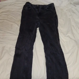 Svarta jeans från Pull&Bear - Snygga svarta jeans från Pull&Bear med en klassisk femficksdesign. De har slits och rak passfptm, högmidjade. Perfekt för en avslappnad stil.