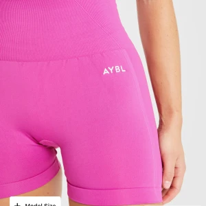 Rosa shorts från AYBL - Säljer ett par snygga rosa shorts från AYBL. De är högmidjade och har en tight passform, perfekta för träning. Materialet är stretchigt och bekvämt, ingen slitage på loggan, scrunch. Säljer likadana i mörkgröna 