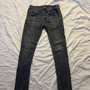 Gråa jeans från Dondup - Gråa jeans från Dondup i en mer slim passform. Bra skick, men notera att klassiska ”D” på bakfickan tyvärr ramlat av. Storlek 29