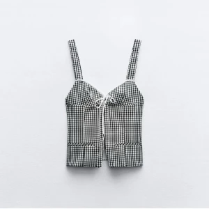 Svartvit rutig korsettopp - Trendig svartvit rutig korsettopp med knytning framtill! Säljer då den inte passar mig!💕 Ej använd 💕 Pris kan diskuteras!