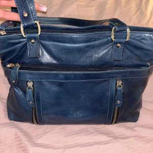 Blå skinnväska från The Monte - Snygg blå skinnväska från The Monte med flera dragkedjor och praktiska fack. Perfekt för att hålla ordning på dina saker. Väskan är vintage med marinblå färg. Kontakta mig gärna vid frågor eller intresse!🩷