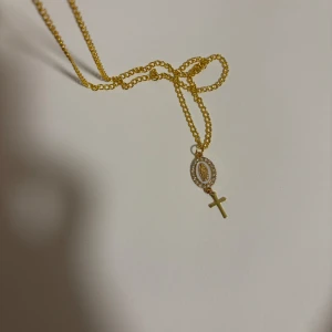 Guldhalsband med korshänge - En väldigt fin elegant kors halsband med helgon maria på. Finns olika halsband i min plick både silver och guld. Om man önskar sig armband så kan vi lösa det🤩