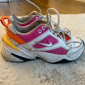 Nike sneakers  - Färgglada Nike sneakers med en mix av vitt, rosa och orange. Slitage i hälarna 
