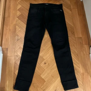 Svarta jeans från Replay - Snygga svarta jeans från Replay, modell Anbass. De har en klassisk femficksdesign och en modern passform. Perfekta för en stilren look.