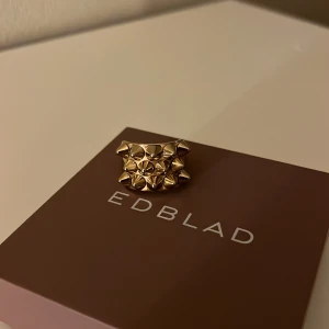 Guldfärgad nit ring från Edblad - Snygg guldfärgad ring från Edblad med ett unikt designmönster av små pyramidformade nitar. Pris kan diskuteras 