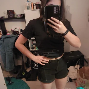 Svarta shorts med knapp - Snygga svarta shorts med hög midja och knapp framtill. Perfekta för en avslappnad stil.