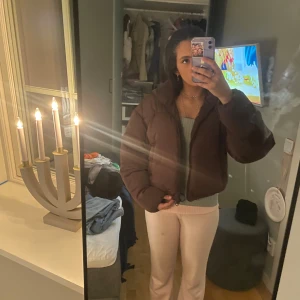 Brun pufferjacka y2k - Säljer en brun pufferjacka med dragkedja. Jackan har en oversized passform och är perfekt för kyligare dagar. Den är långärmad och har en mysig, quiltad design som håller dig varm och stilren.