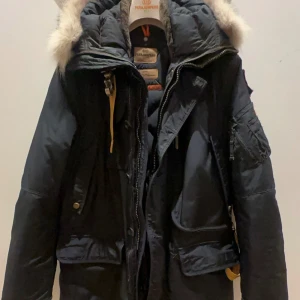 Parajumpers Kodiak Masterpiece Parka - Säljer en välbehållen Parajumpers Kodiak Materpiece Parka i storlek M med äkta naturpäls. Praktiska och dekorativa detaljer, förstärkta armbågar, avtagbar hake i halsen, praktiska fickor varav en stängs med dragkedja. Flera innerfickor och dragkedjor nedtill i sidorna för justerbar passform. Ingår i Parajumpers Masterpiece Series bestående av deras exklusivaste modeller.  Äkthetscertifikat, kvitto samt tillbehör följer med. Jackan har köpts på Careofcarl.