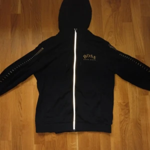 Svart huvtröja från Hugo Boss - Säljer en stilren svart huvtröja från Hugo Boss med dragkedja. Sällsyn model ,pris kan sänkas vid snabb affär.Den är storlek M men passer också storlek S.