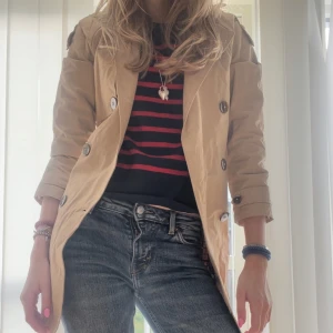 Beige trenchcoat med knappar💋🫐 - Snygg beige trenchcoat med knappar och bälte i midjan. Perfekt för höst 🍁och vår🌷. Jackan har långa ärmar och en klassisk krage. Kappan är aldrig använd och i mycket bra skick. gammal designe från Zara och går inte att hitt längre.💄Orginal pris 500kr 🧥