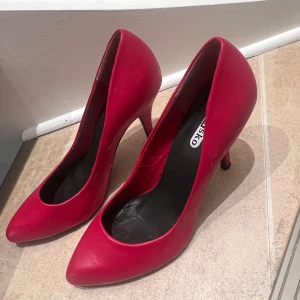 Röda pumps från Din Sko - Snygga röda pumps från Din Sko med spetsig tå och klack. Perfekta för att ge en färgklick till din outfit. Tillverkade i ett slätt material som ger en elegant look.