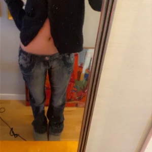 Mörkblå bootcut jeans med slitningar - Snygga mörkblå jeans med coola slitningar och en klassisk femficksdesign. De har en lågmidjad passform och utsvängda ben. Perfekta för en avslappnad stil.