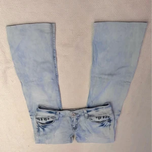 Ljusblå jeans med broderade detaljer - Snygga ljusblå jeans med unika broderade detaljer vid fickorna. De har en klassisk femficksdesign och en knappgylf. Perfekta för en avslappnad stil med en touch av något extra. Köpte på Plick men säljer då dom ej passade💕midjemåttet: 39 cm innebenslängden: 76cm