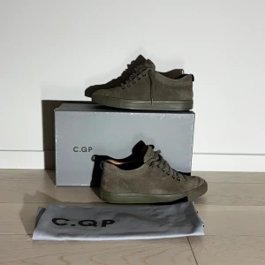 Mörkgröna mockasneakers från C.QP - Snygga gröna sneakers i mocka från C.QP. Skorna har en stilren design med snörning och en matchande grön sula. Perfekta för en trendig look.      