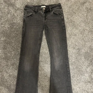Grå jeansbyxor - Snygga lågmiddjade bootcut jeans! Har knappar i bak och har två knappar i fram. Jättesnygga!