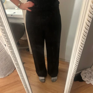 Svarta byxor - Snygga svarta byxor med hög midja och rak passform. Perfekta för en stilren look. Byxorna är tillverkade i ett mjukt material som ger en bekväm känsla hela dagen.